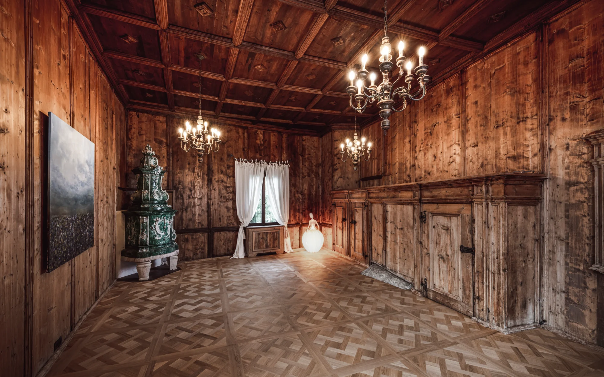 Grand, wood-paneled room with chandeliers, perfect for an Italian wedding at Relais & Châteaux Castel Fragsburg.
