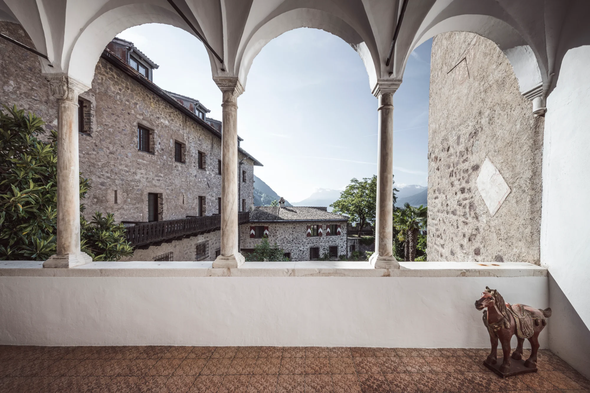 Stone archway overlooking a courtyard and mountains; perfect for an Italian wedding at Relais & Châteaux Castel Fragsburg.