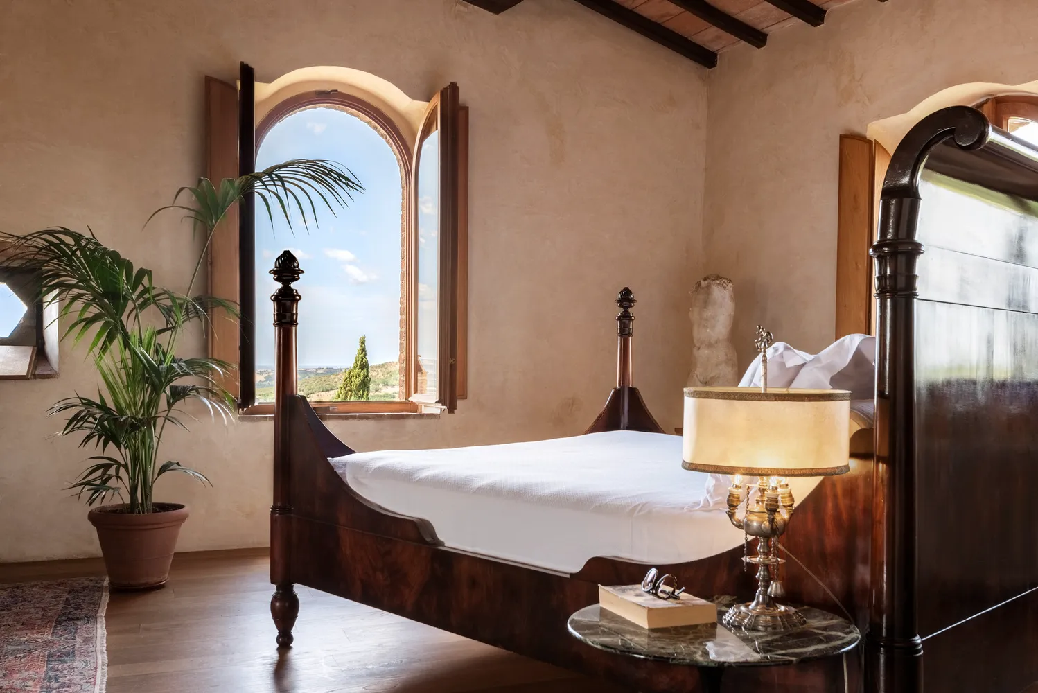 Luxurious bedroom at Castello Di Vicarello, featuring a four-poster bed and stunning views.