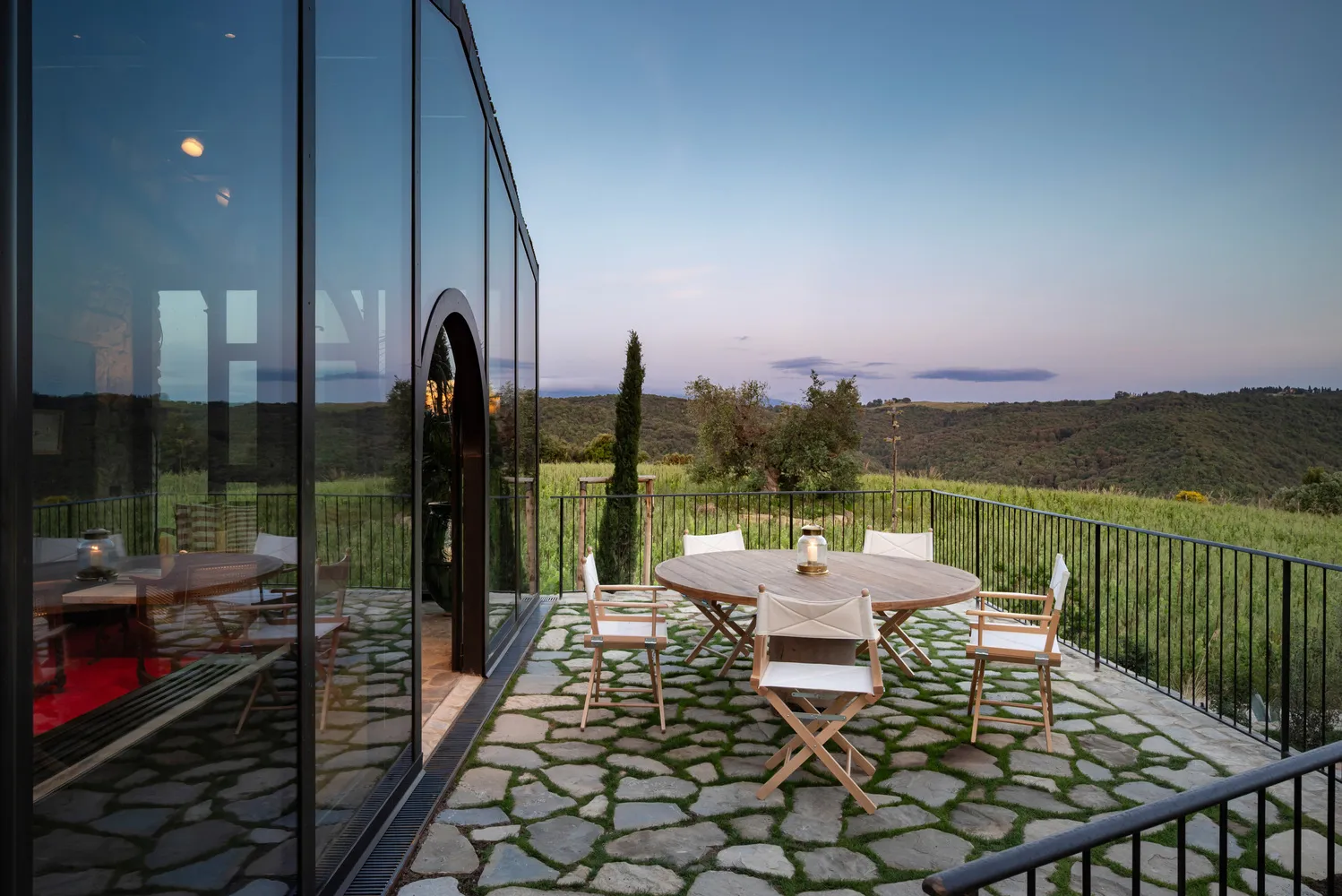 Outdoor patio at Castello Di Vicarello with round table and chairs, overlooking Tuscan vineyards. Perfect castle wedding venue.