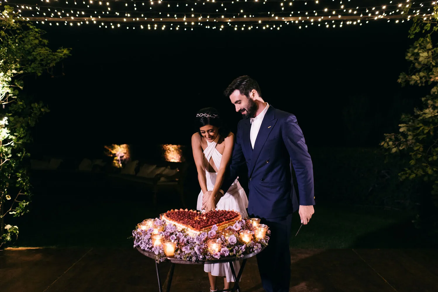 Happy couple cutting their wedding cake at Castello Di Vicarello, a stunning castle wedding venue.