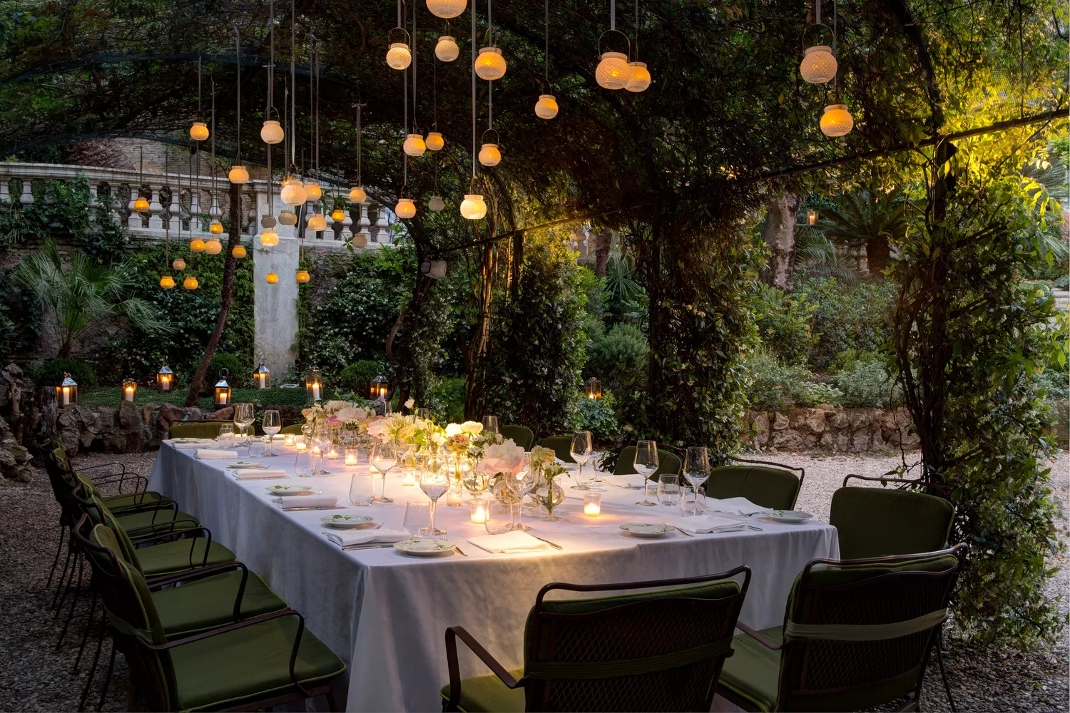 Romantic outdoor wedding reception at Hotel De Russie in Rome. Elegant table setting under twinkling lights.