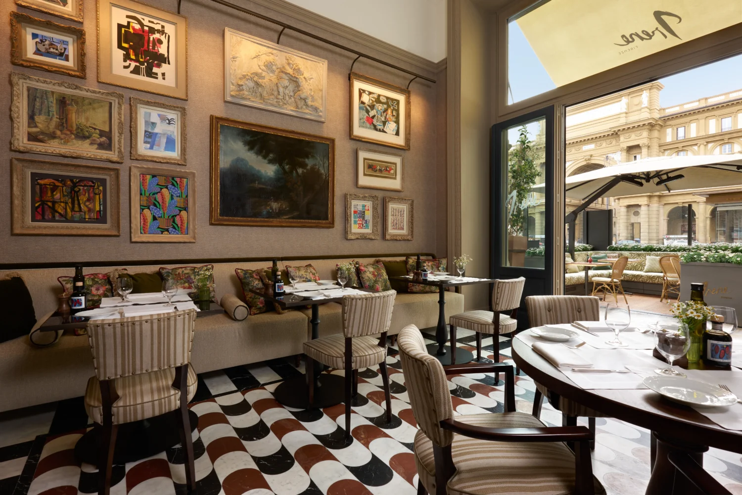 Elegant dining room at Hotel Savoy, Florence, Italy. Tables set for two, art-filled walls.
