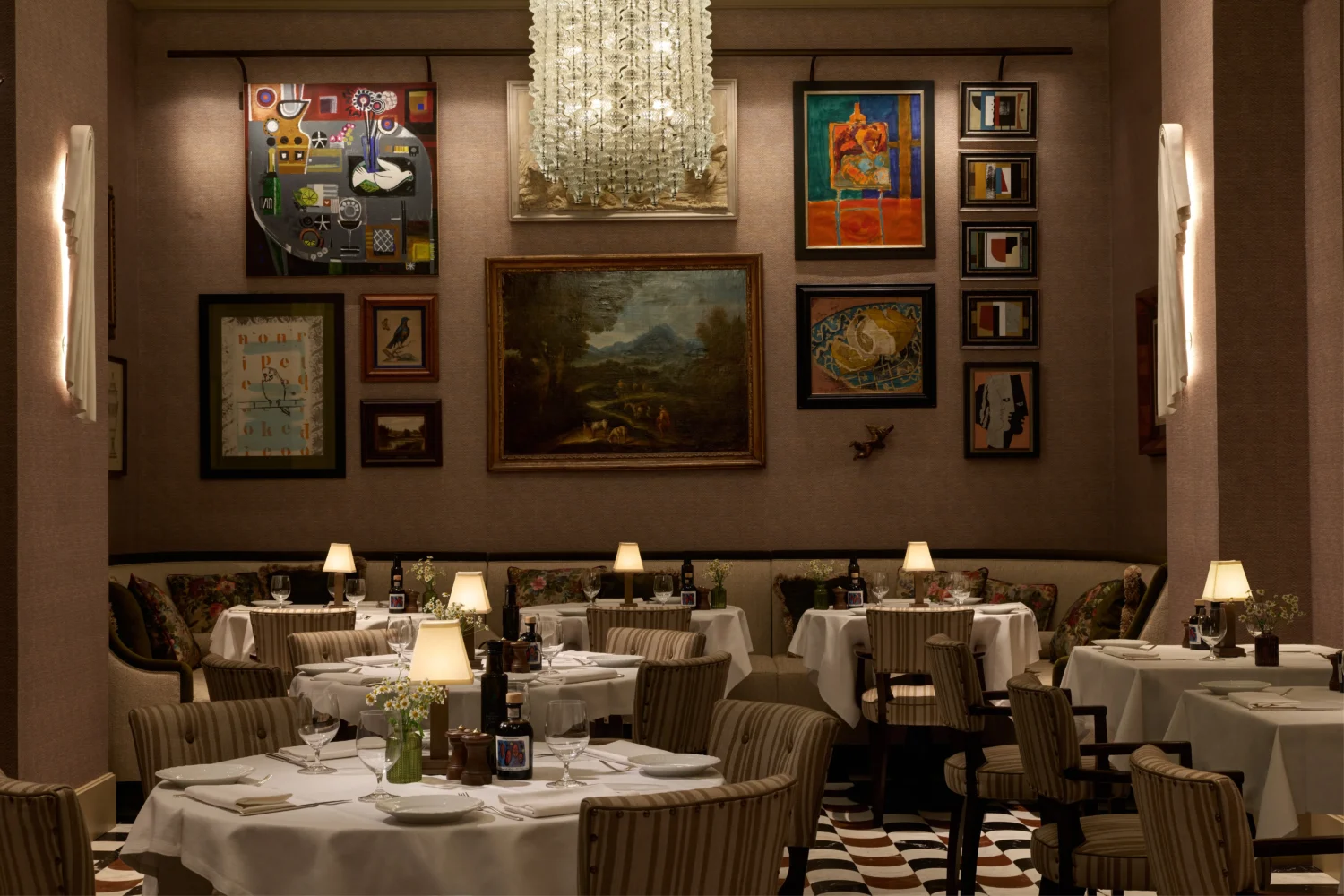 Elegant dining room at Hotel Savoy, Florence. Tables set for dinner, art-filled walls.