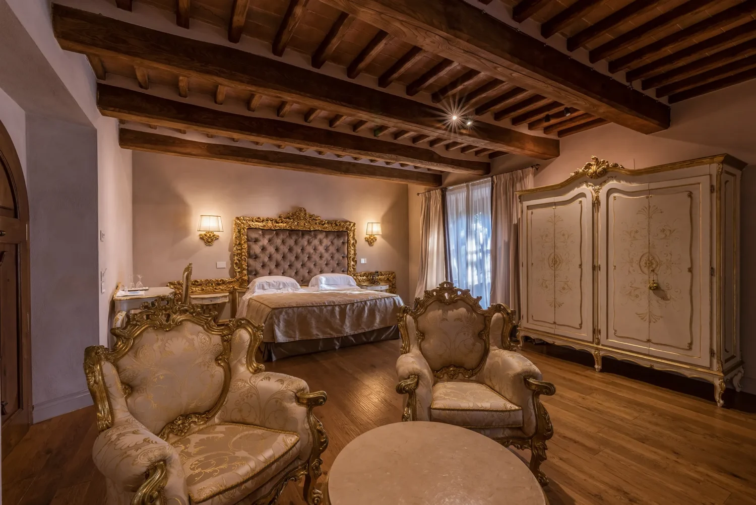 Luxurious bedroom with ornate furniture and wooden beams, perfect for an Italian Countryside wedding.