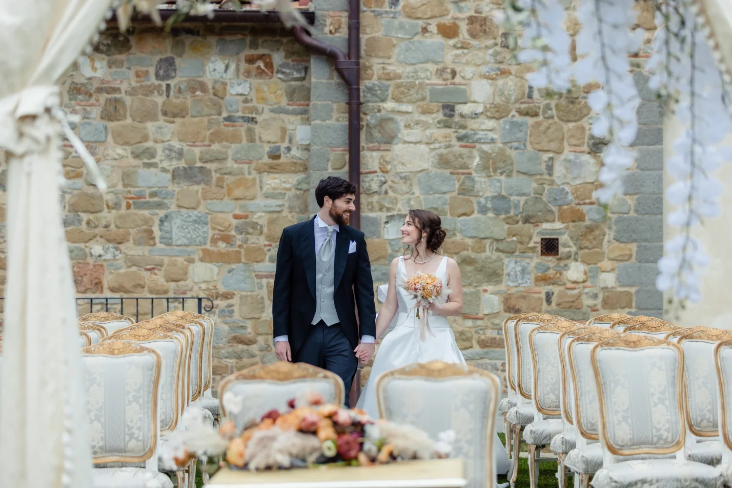 Happy couple holding hands at their Italian countryside wedding at Relais La Corte Dei Papi.