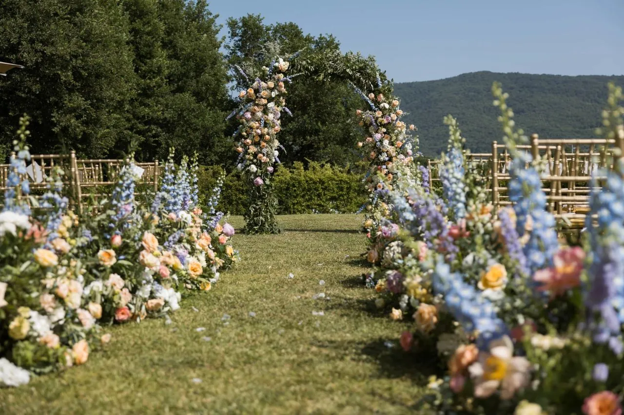 Floral wedding arch and aisle at Relais La Corte Dei Papi, set against the Italian countryside.