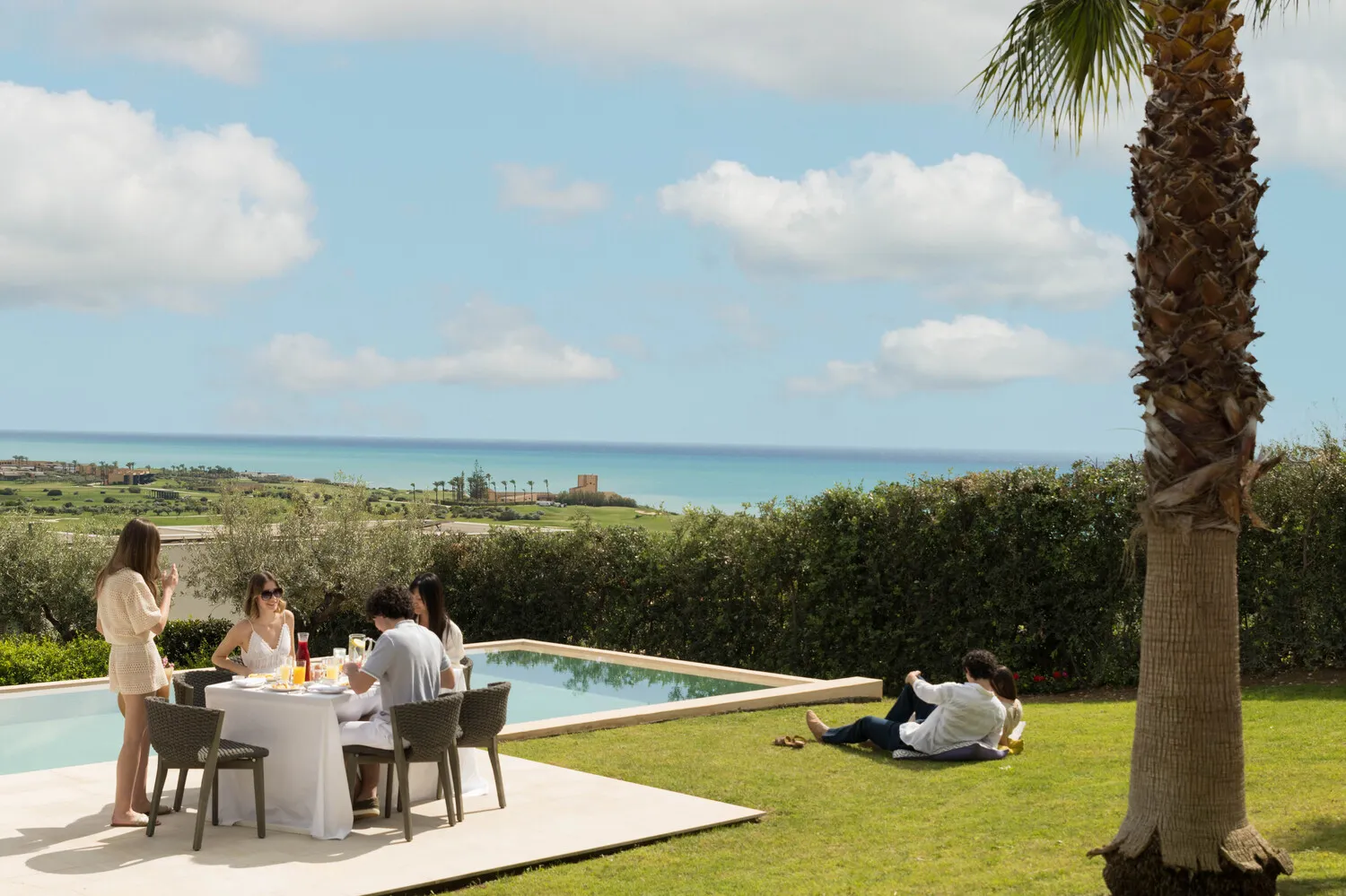 Guests enjoy a meal overlooking the ocean at a luxurious Sicily resort. Destination wedding location.