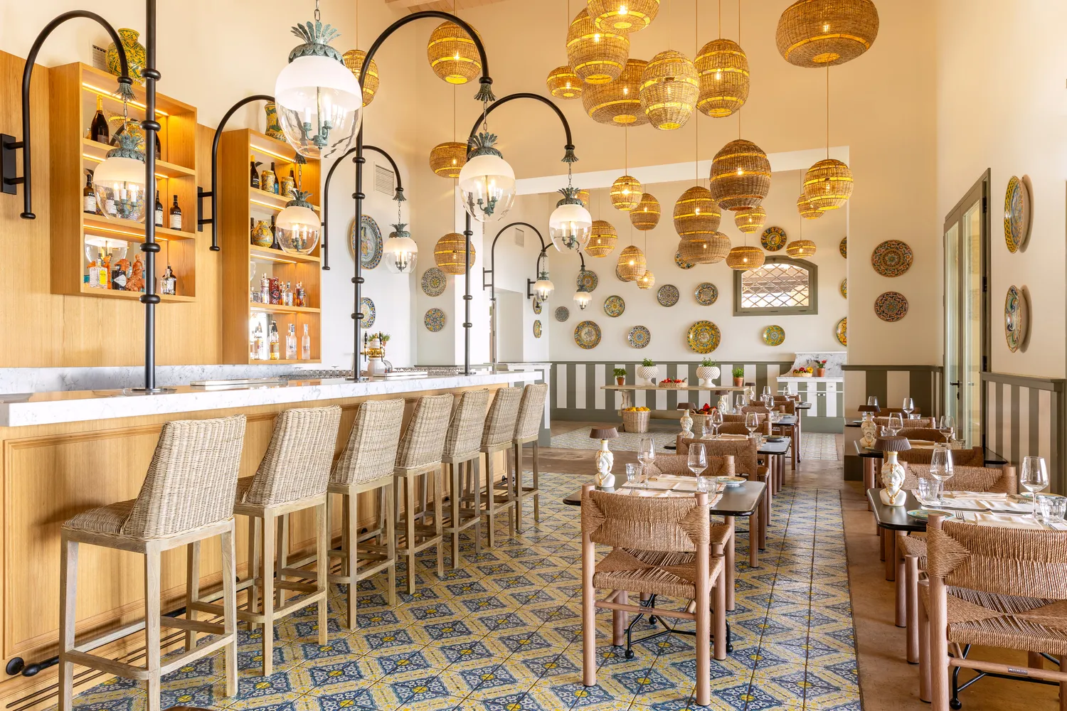 Elegant restaurant at Verdura Resort, Sicily, featuring a bar and dining area with wicker chairs.
