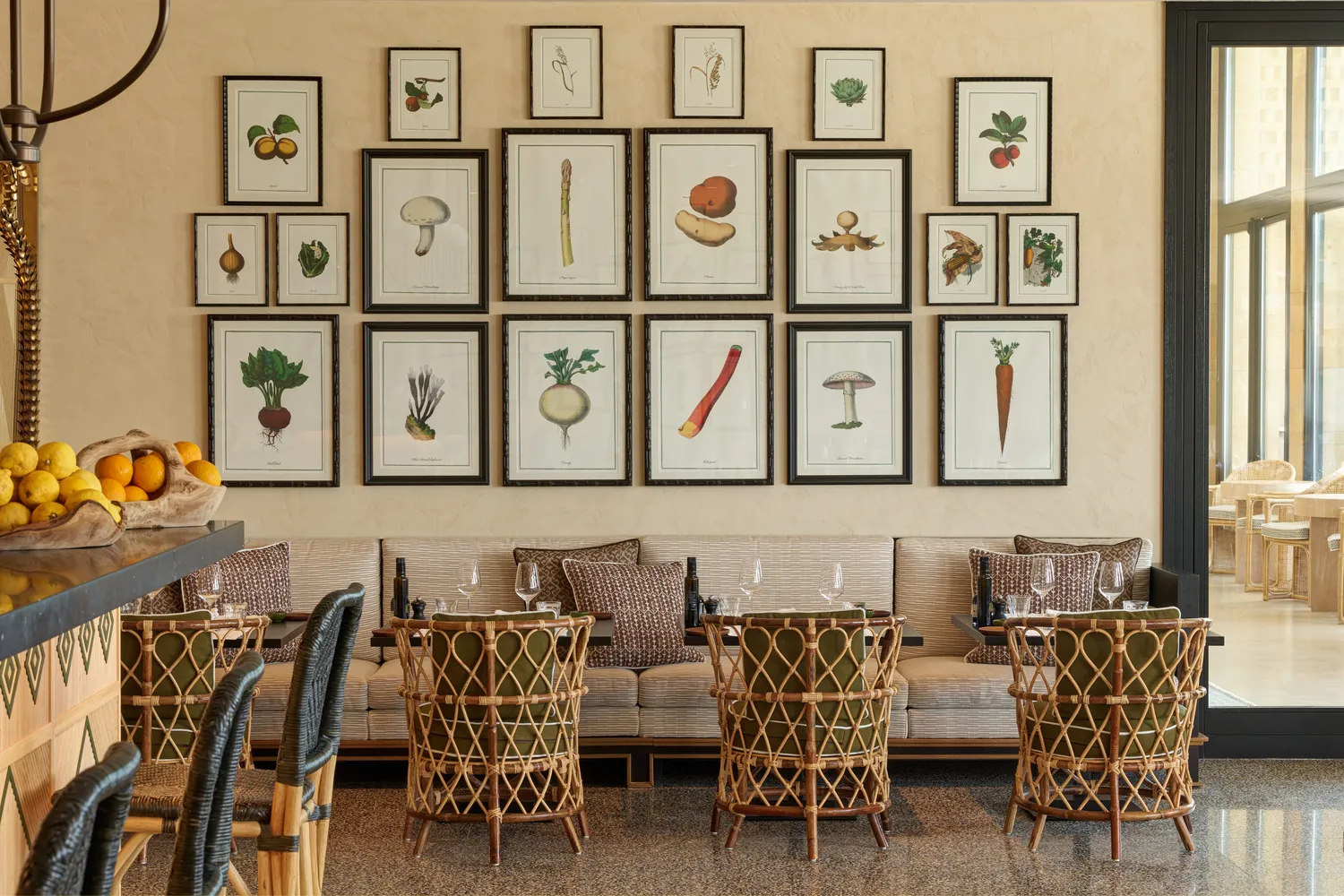 Elegant dining area at Verdura Resort in Sicily, featuring botanical prints and wicker chairs.
