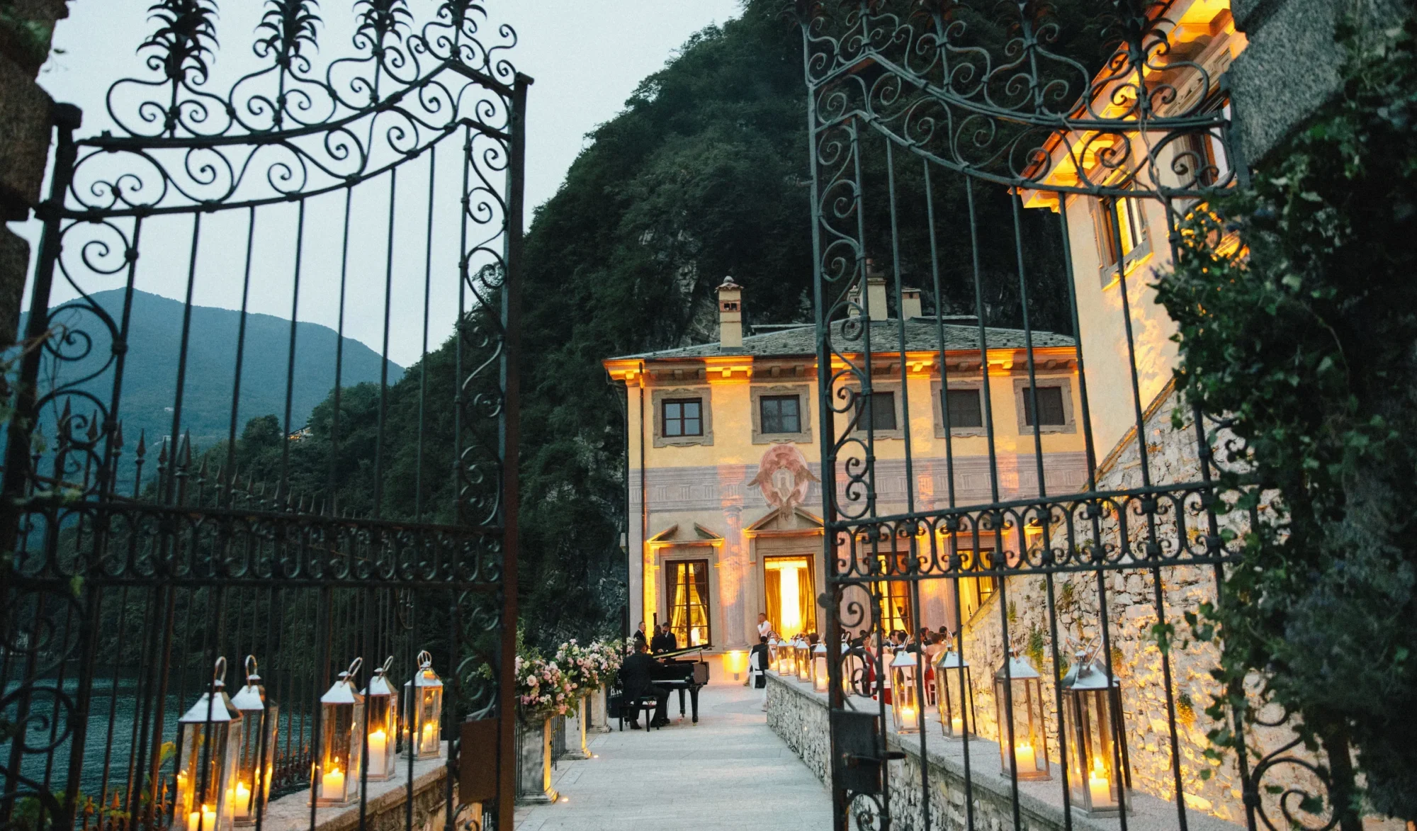 Grand entrance to a Private Italian Wedding Villa, Villa Pliniana, with a piano and guests visible.