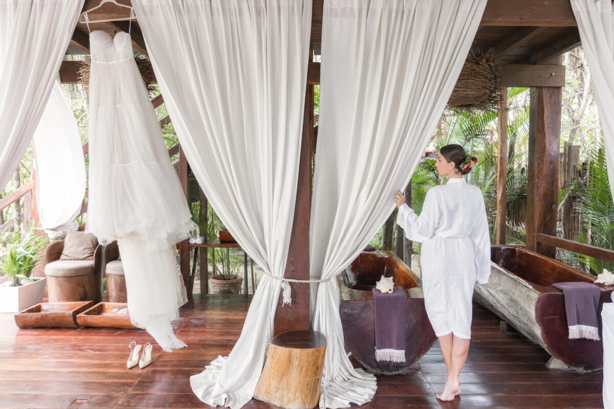 Bride in robe near wedding dress at Jashita Hotel Tulum, a Tulum wedding venue.