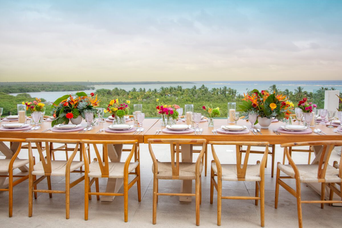 Elegant outdoor dining table setup with tropical flowers at Jashita Hotel Tulum, a stunning Tulum wedding venue.