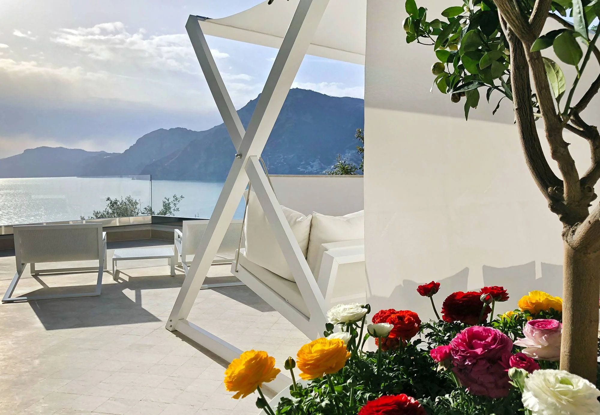 White patio furniture with ocean view; Amalfi Coast wedding venue.