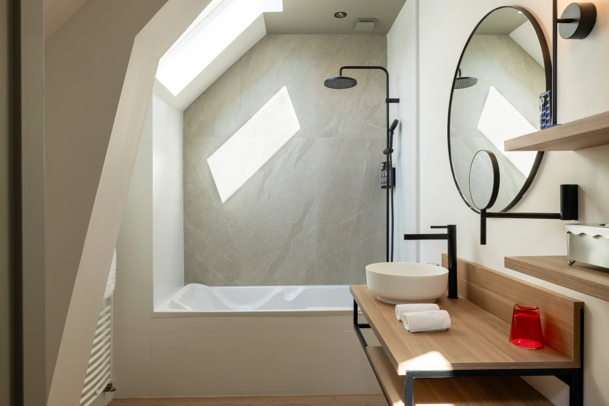 Modern bathroom with bathtub and shower, ideal for a relaxing stay at a French castle wedding venue like Domaine de la Bretesche.