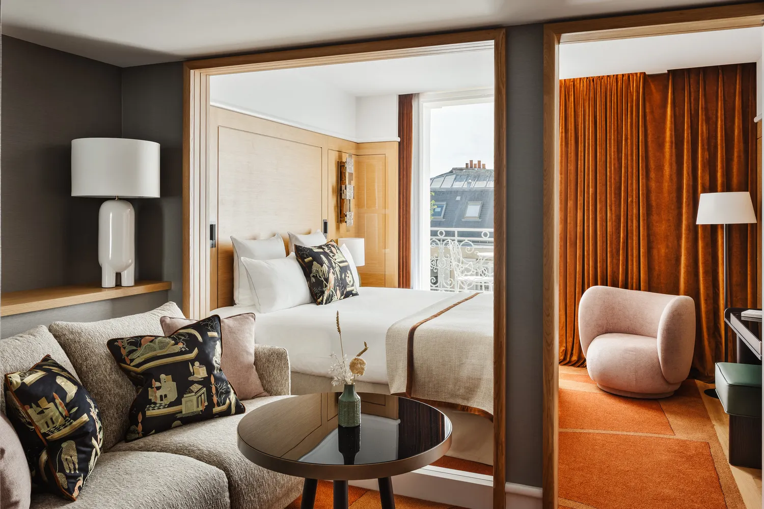 Luxurious Parisian hotel suite with sitting area and bedroom, ideal for a romantic getaway or wedding.