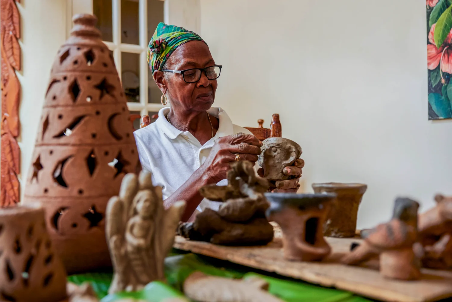 Elderly woman crafts clay pottery.