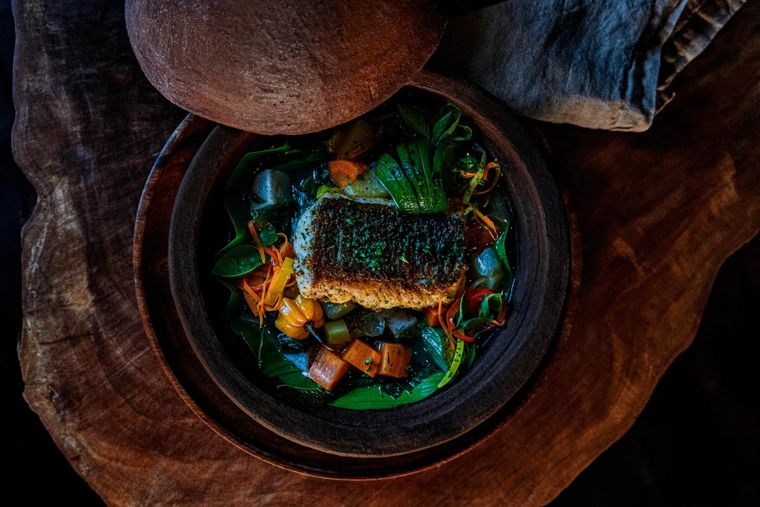 Delicious fish stew in a rustic clay pot, perfect for a romantic island honeymoon at Ladera Resort.