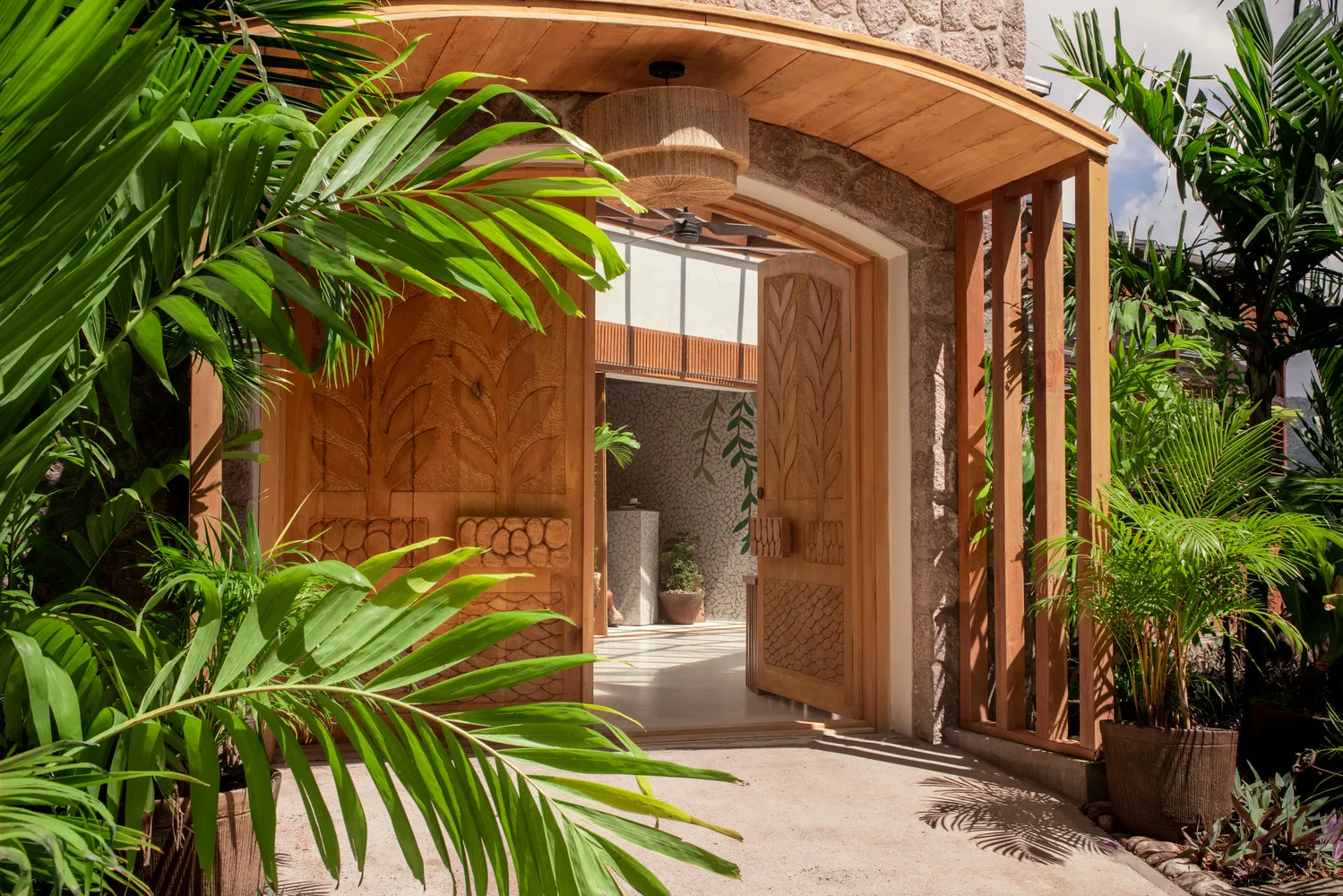 Ornate wooden doors open to a tropical courtyard at Ladera Resort, perfect for an island wedding or honeymoon.