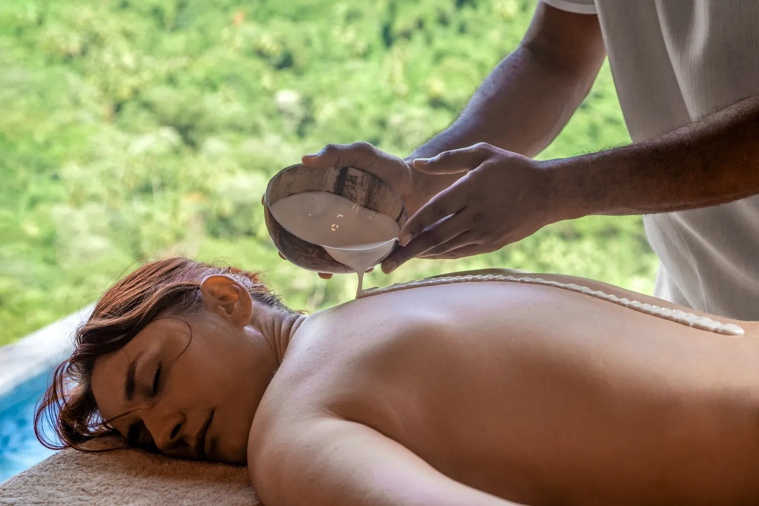 Relaxing back massage with coconut milk at a luxurious resort. Ideal for island honeymoon or wedding.