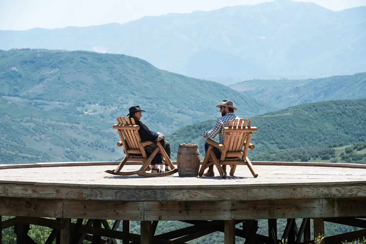 Couple relaxing in rocking chairs overlooking a mountain vista at The Lodge at Blue Sky, a Utah ranch wedding venue.