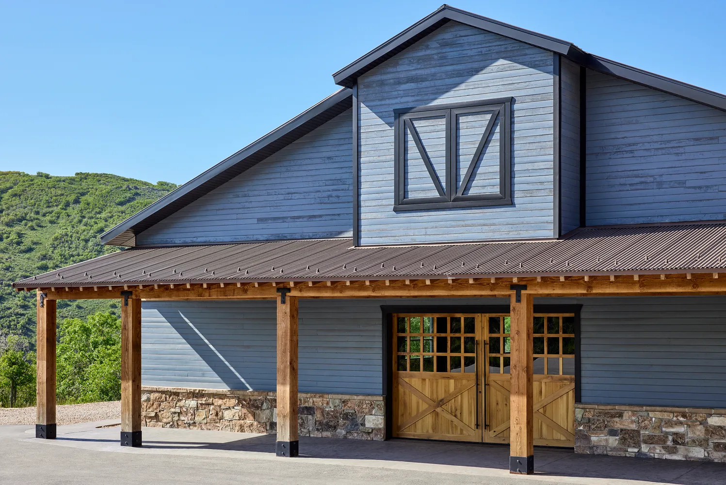 Exterior of The Lodge at Blue Sky, featuring a rustic barn-style building with large wooden doors, perfect for a Utah ranch wedding.
