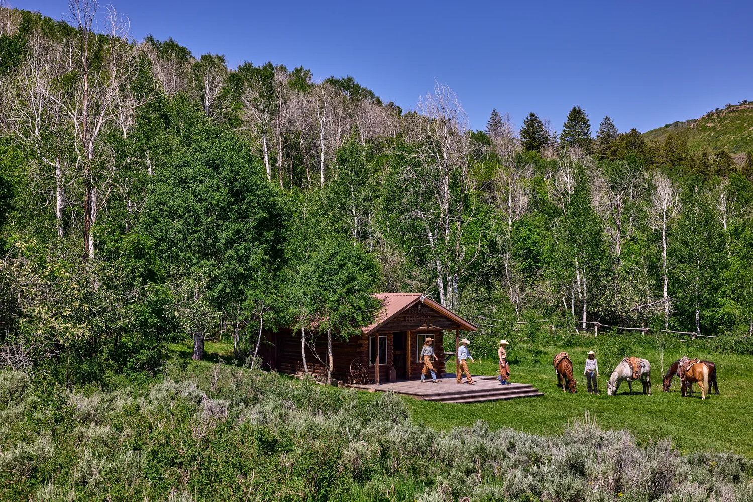 Guests at The Lodge at Blue Sky, Auberge Resorts Collection, enjoy the ranch setting. Horses graze nearby.