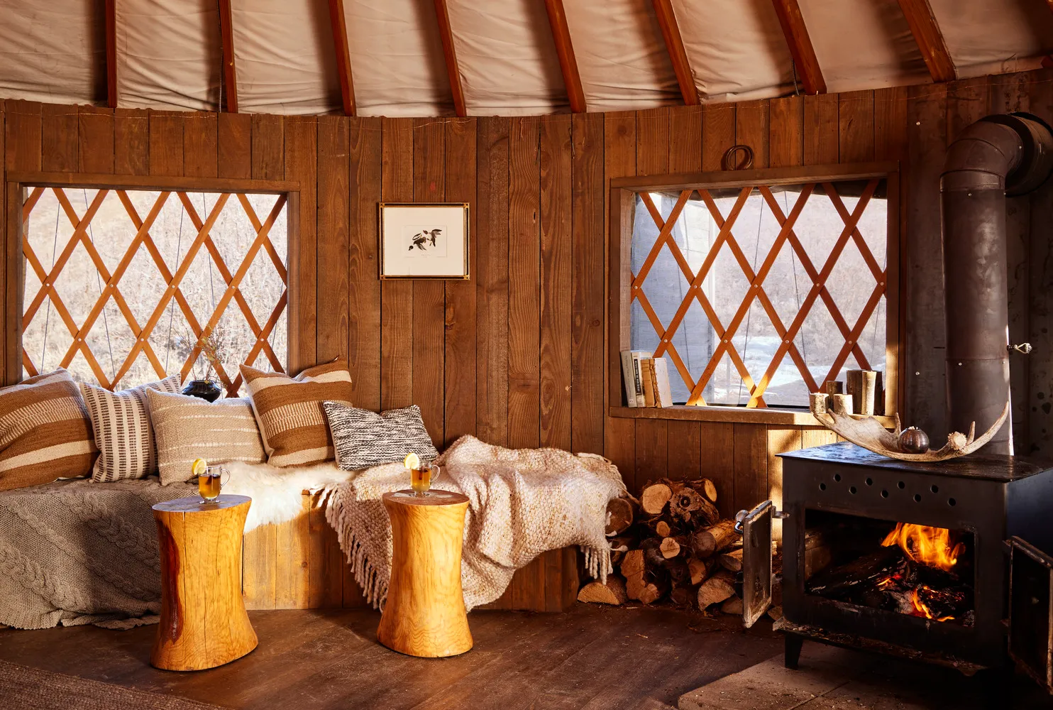 Cozy yurt interior with wood-burning stove, seating area, and warm lighting. Perfect for a Utah ranch wedding.