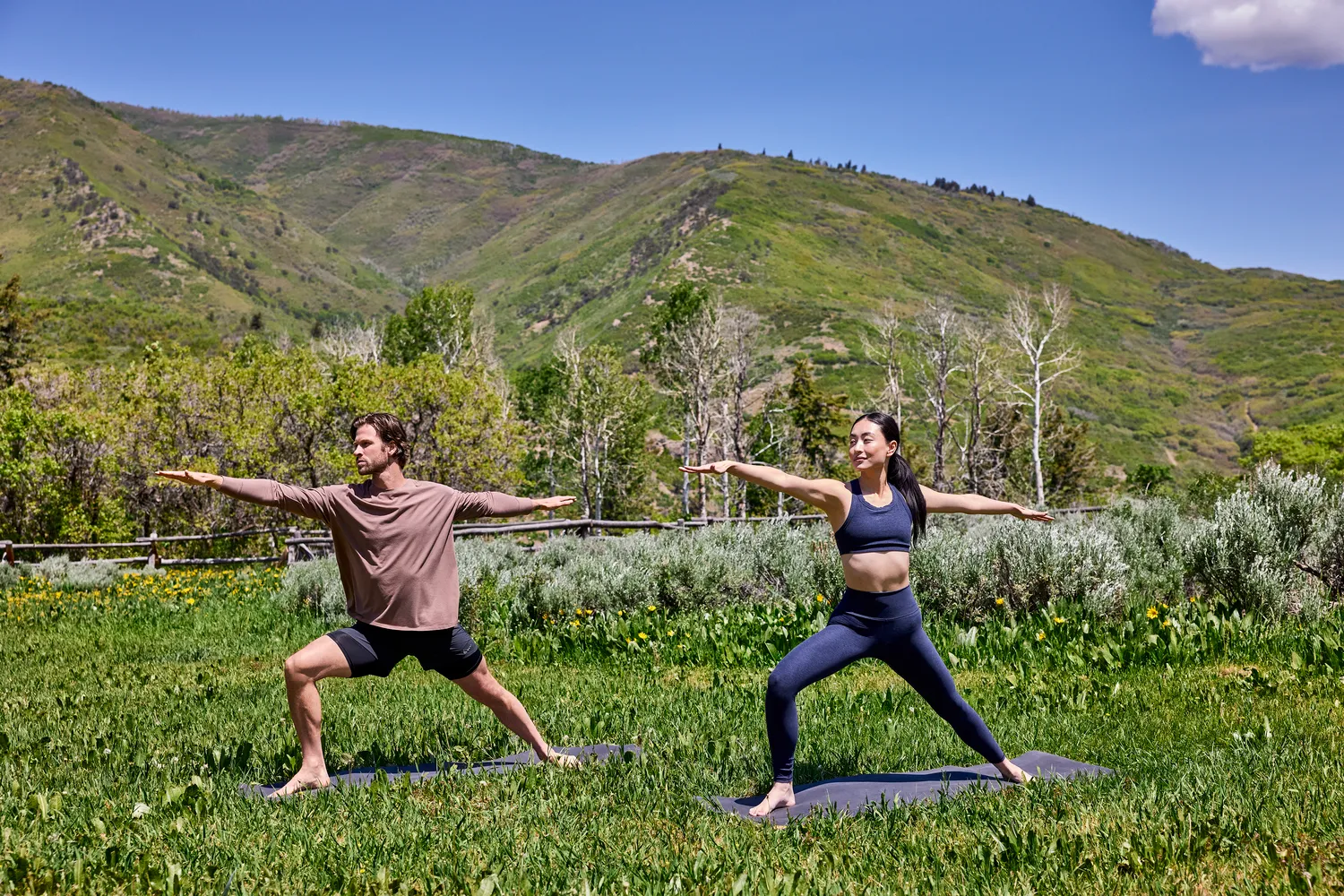 Couple practicing yoga outdoors at The Lodge at Blue Sky, Auberge Resorts Collection.