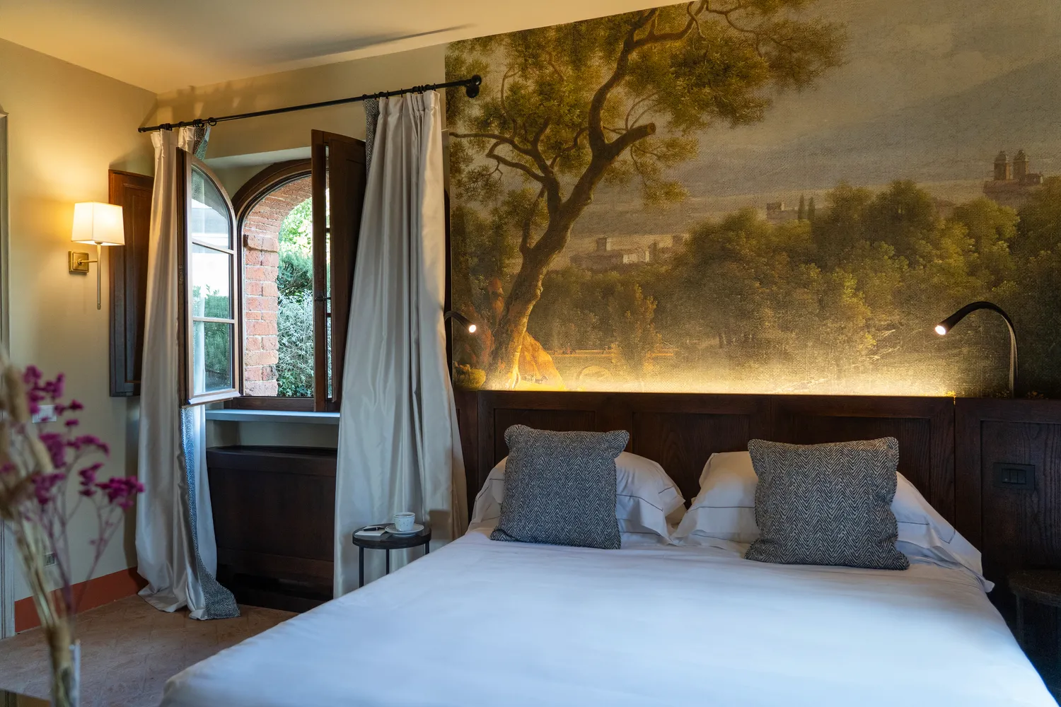 Elegant bedroom in Tuscany with a scenic mural, perfect for a romantic honeymoon or wedding.