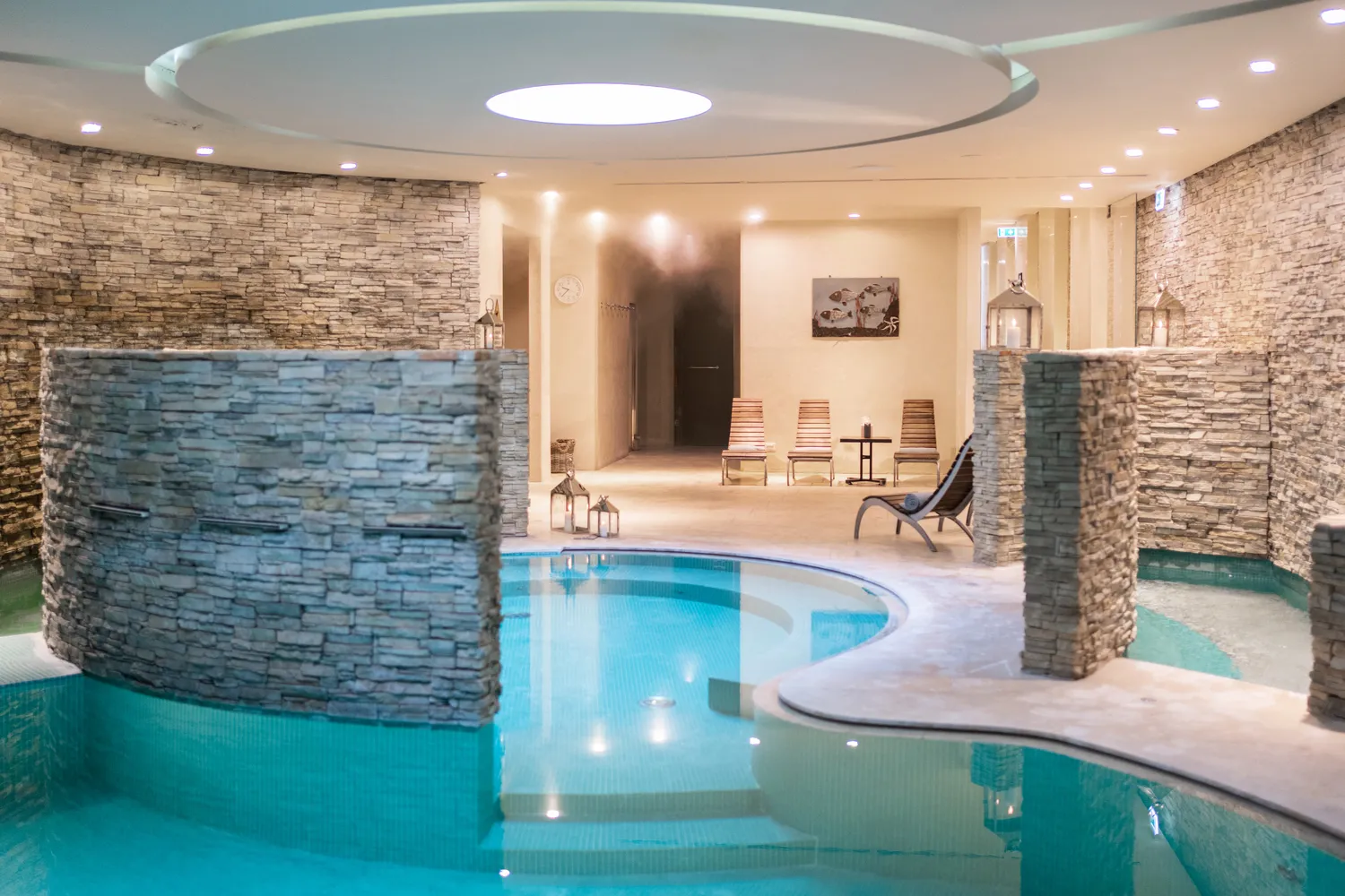 Luxury Tuscan spa pool with stone walls and lounge chairs. Perfect for a relaxing Tuscany honeymoon.