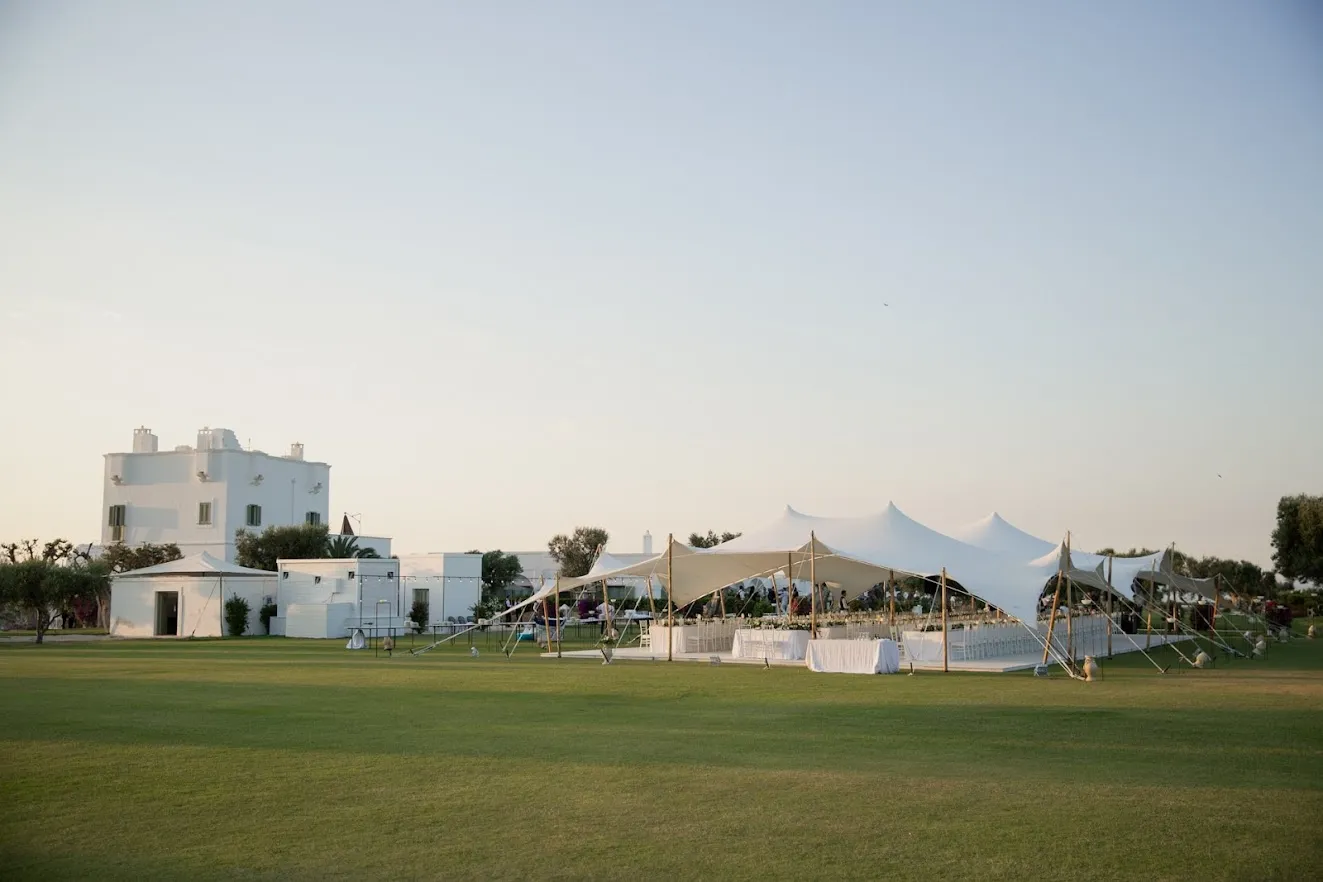 Elegant Puglia wedding reception under a white tent at Masseria Torre Maizza.