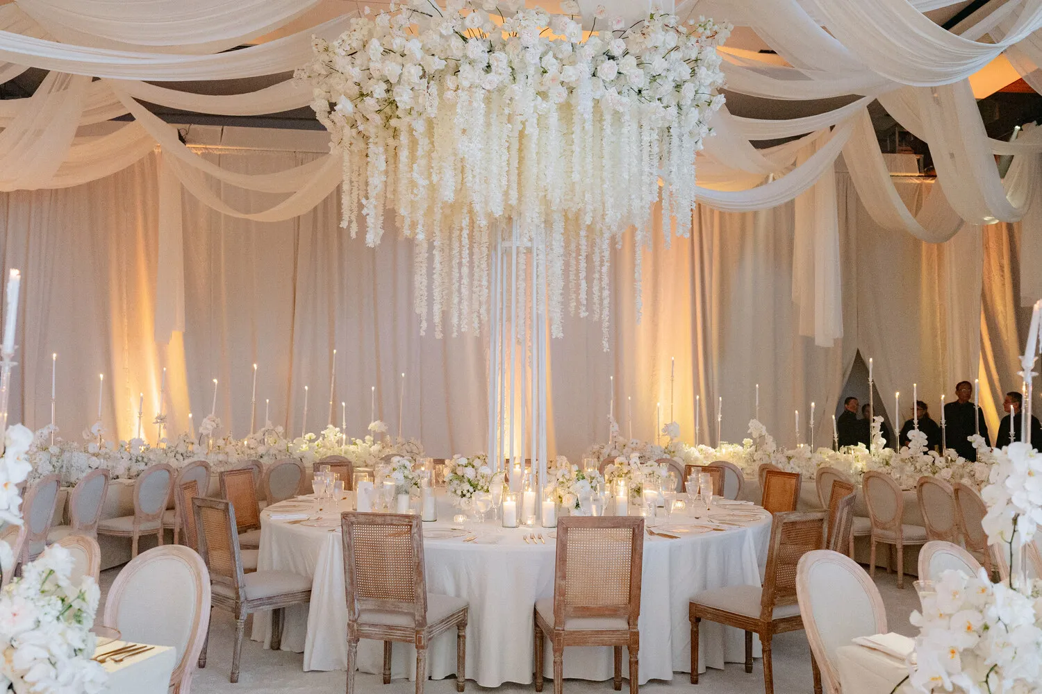 Elegant Cancun wedding reception at NIZUC Resort & Spa, featuring a stunning floral centerpiece and candlelit tables.