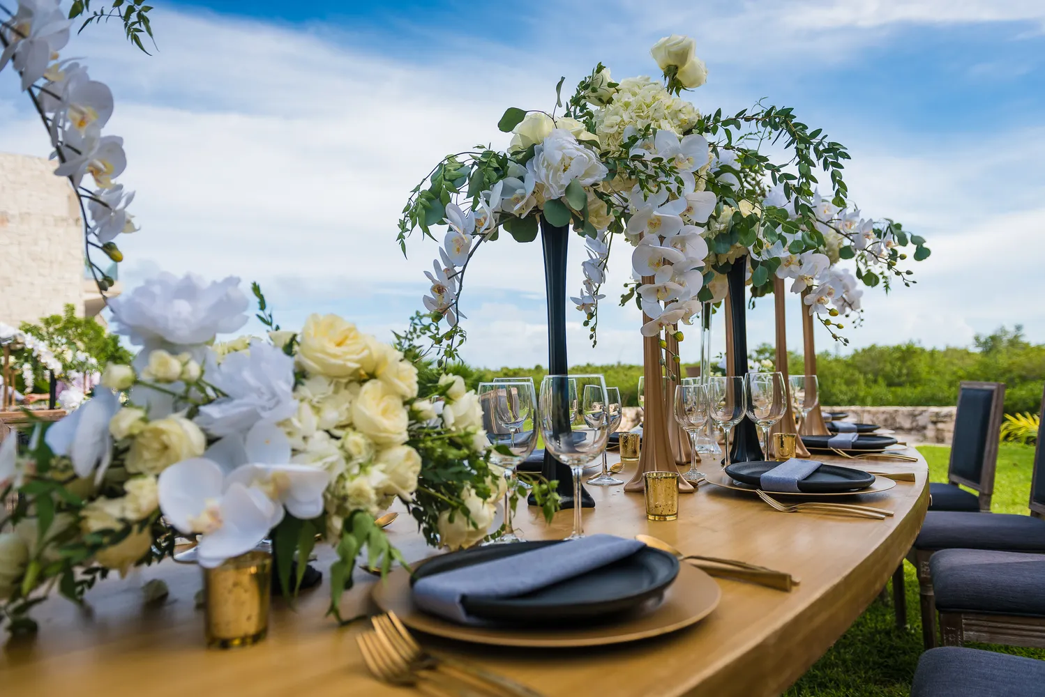 Elegant Cancun wedding reception table setting at NIZUC Resort & Spa with white flowers and gold accents.