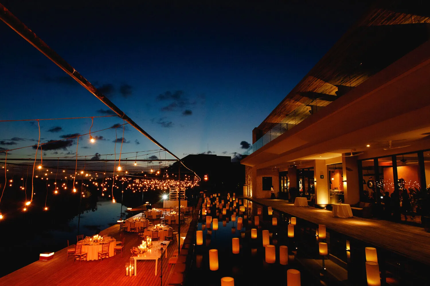 Romantic Cancun wedding reception at NIZUC Resort & Spa, featuring outdoor dining and candlelit water features.