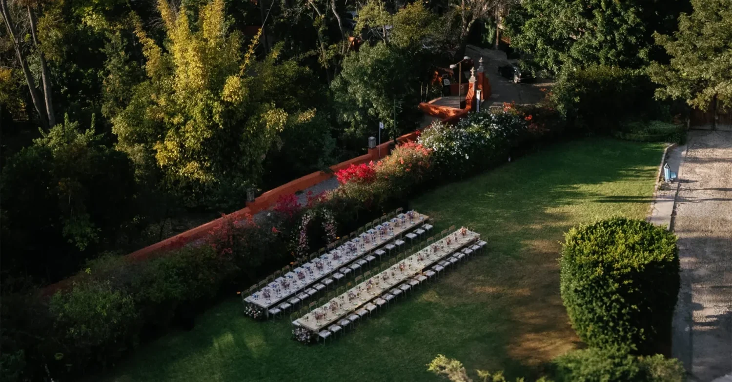 Aerial view of two long wedding reception tables set up on a lush green lawn at Casa de Sierra Nevada, a Belmond Hotel, San Miguel de Allende. Casa de Sierra Wedding.