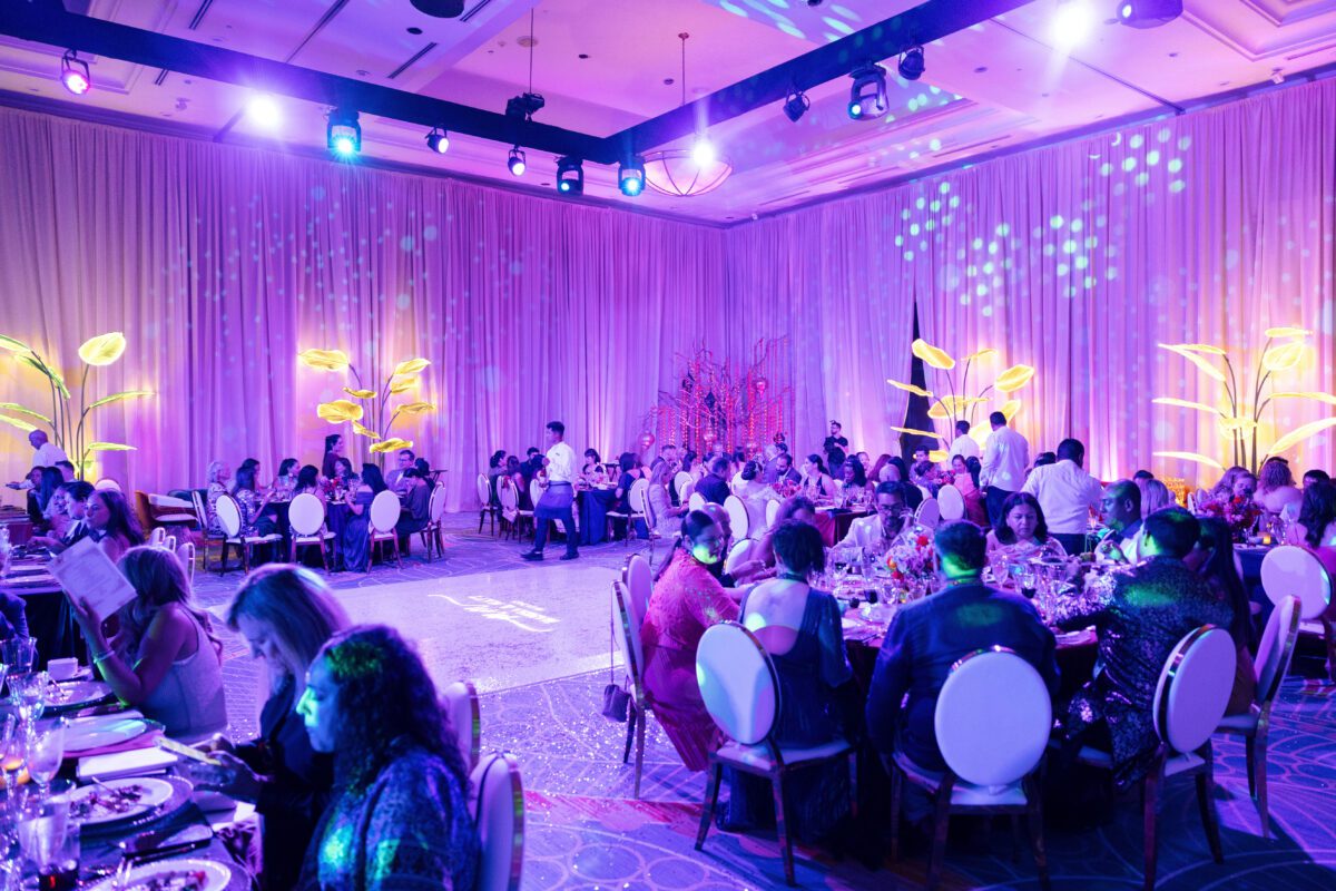 Los Cabos destination wedding reception in a ballroom with purple lighting.