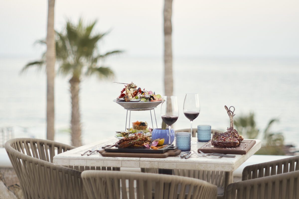 Los Cabos destination wedding feast with steak and seafood at Hilton Los Cabos overlooking the ocean.