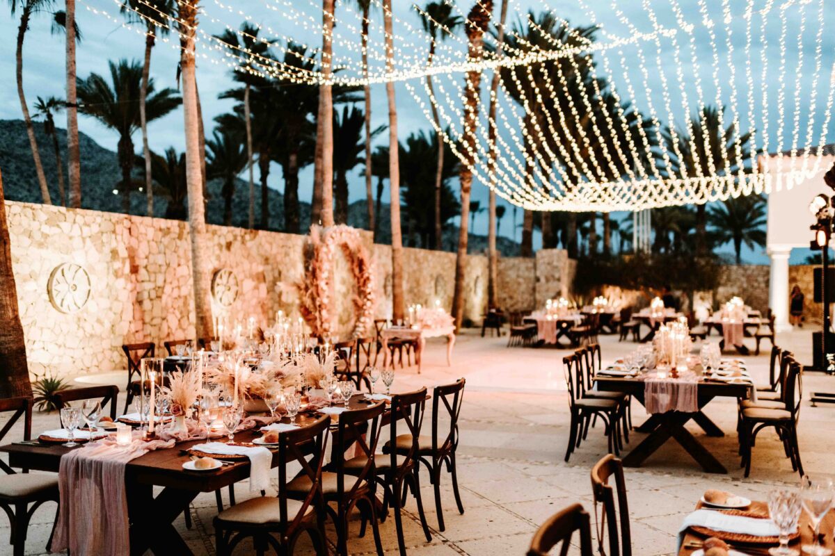 Los Cabos destination wedding reception at Hilton Los Cabos, with tables, chairs, and string lights at dusk.