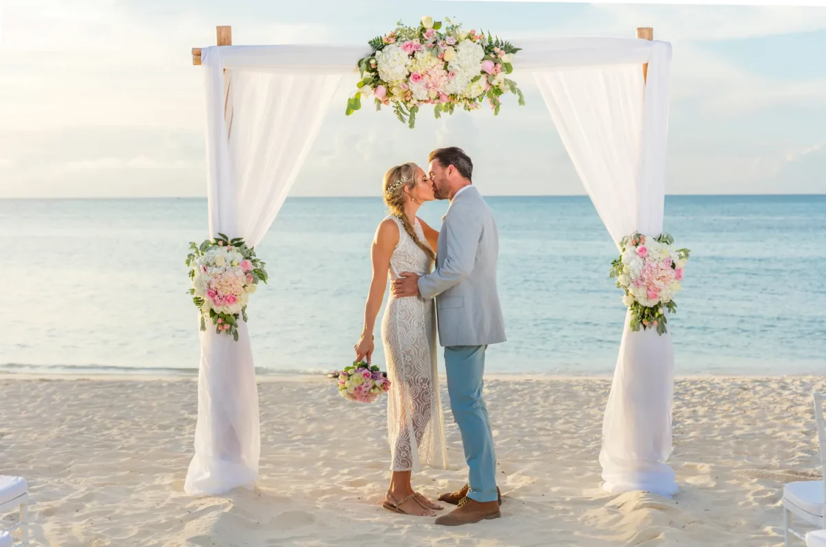 Couple kissing at a Hilton Aruba Destination Wedding ceremony on the beach