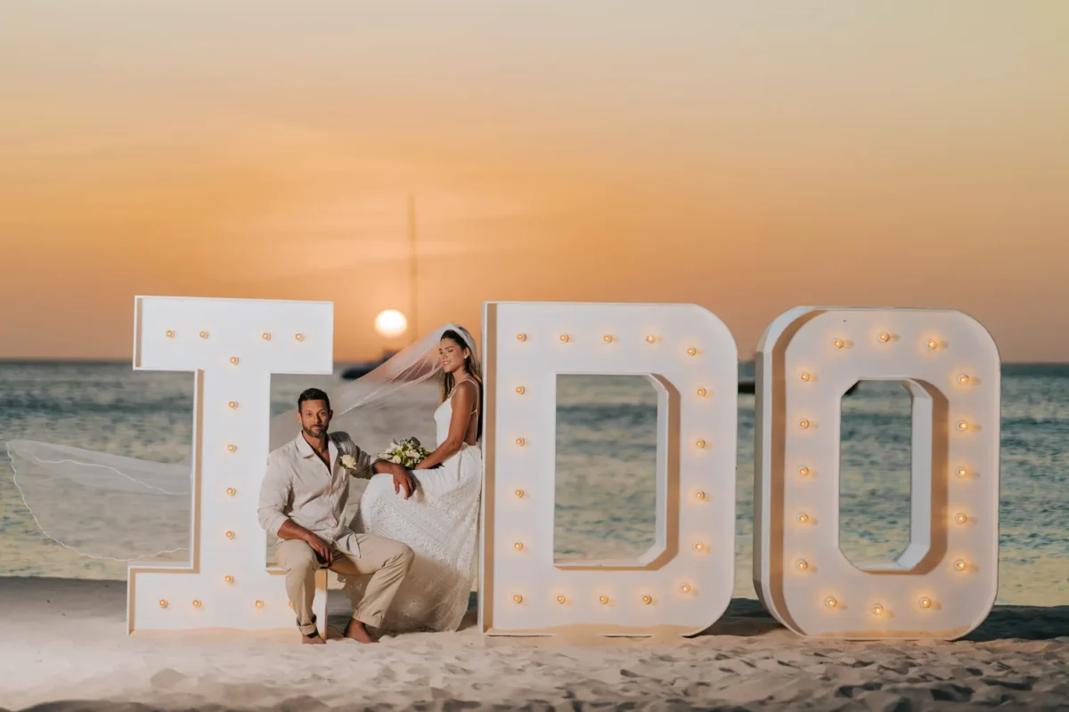 Newlyweds on the beach at sunset with 