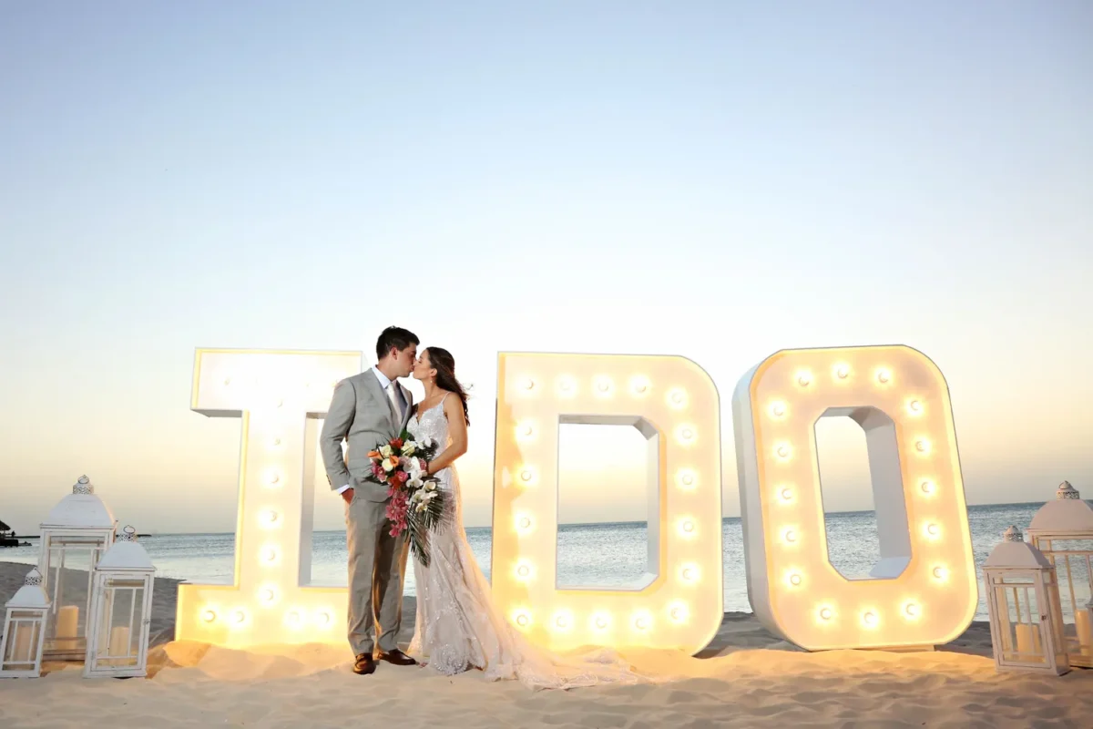 Newlyweds kissing in front of illuminated 
