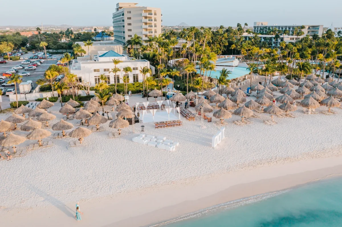 Aerial view of a Hilton Aruba Destination Wedding ceremony setup on a white sand beach.