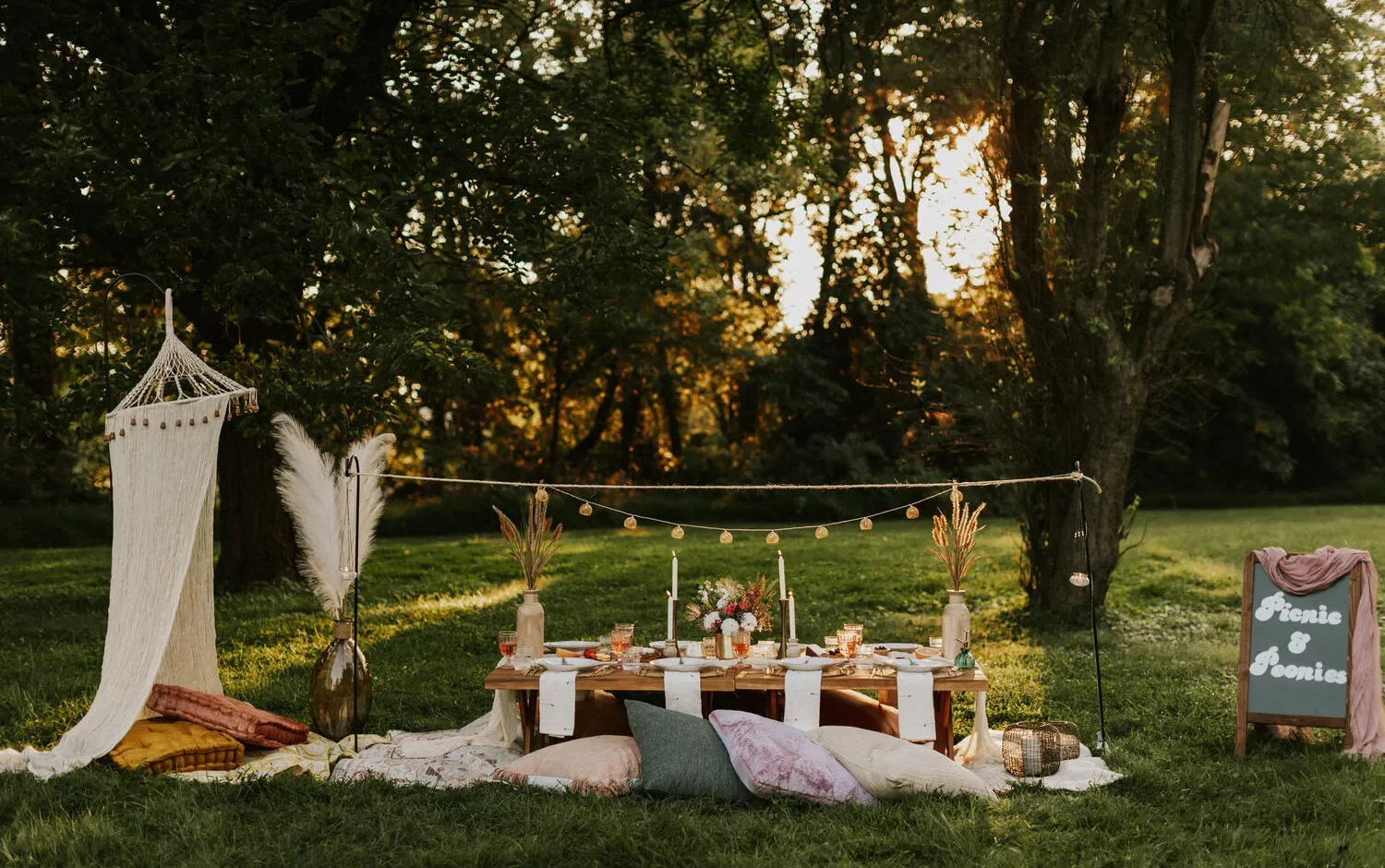 Romantic outdoor picnic setting with low table, pillows, and string lights. Perfect for a NYC wedding.