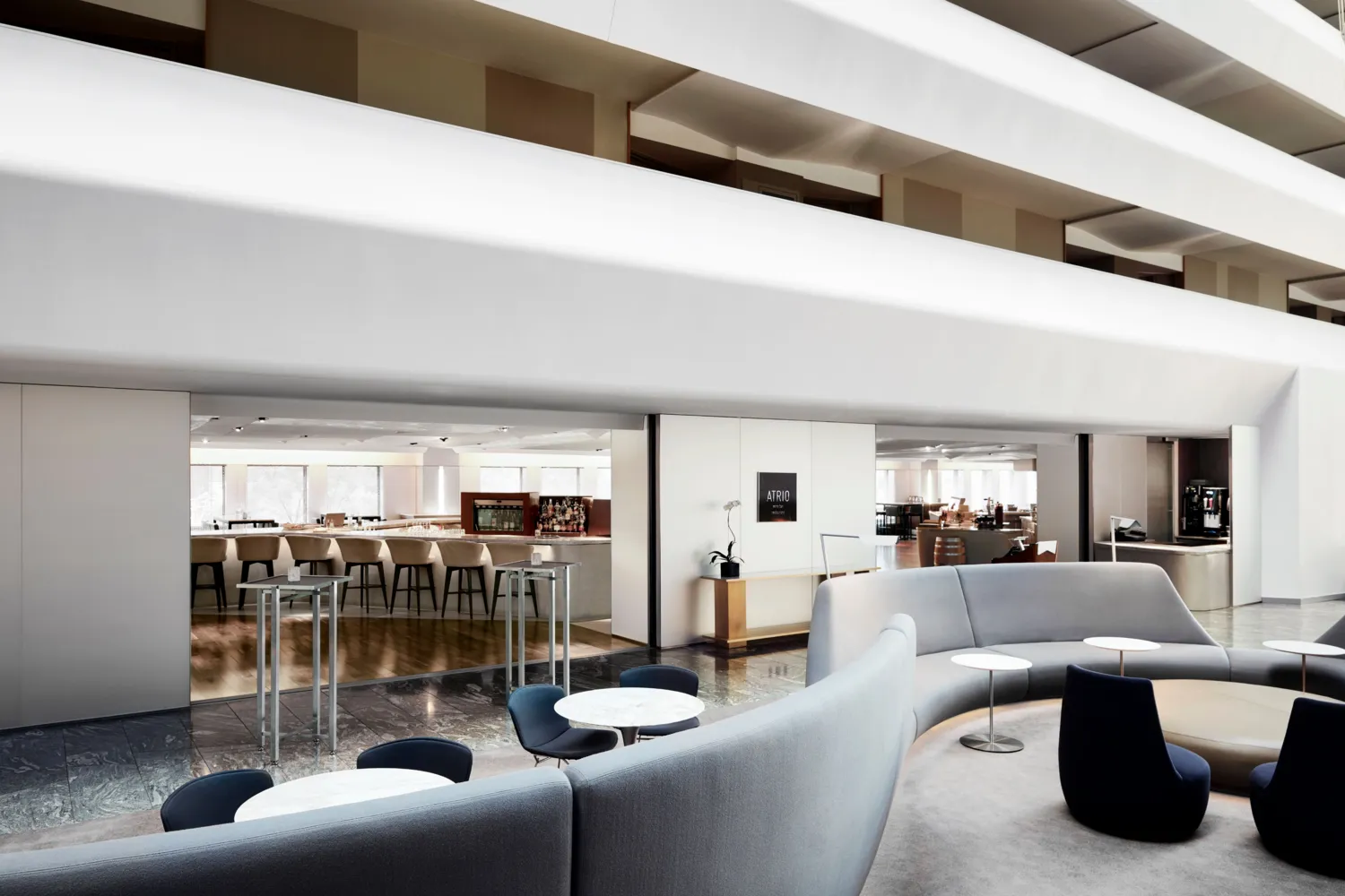 Modern lobby lounge at Conrad New York Downtown, featuring curved seating and a bar. Perfect for NYC wedding receptions.