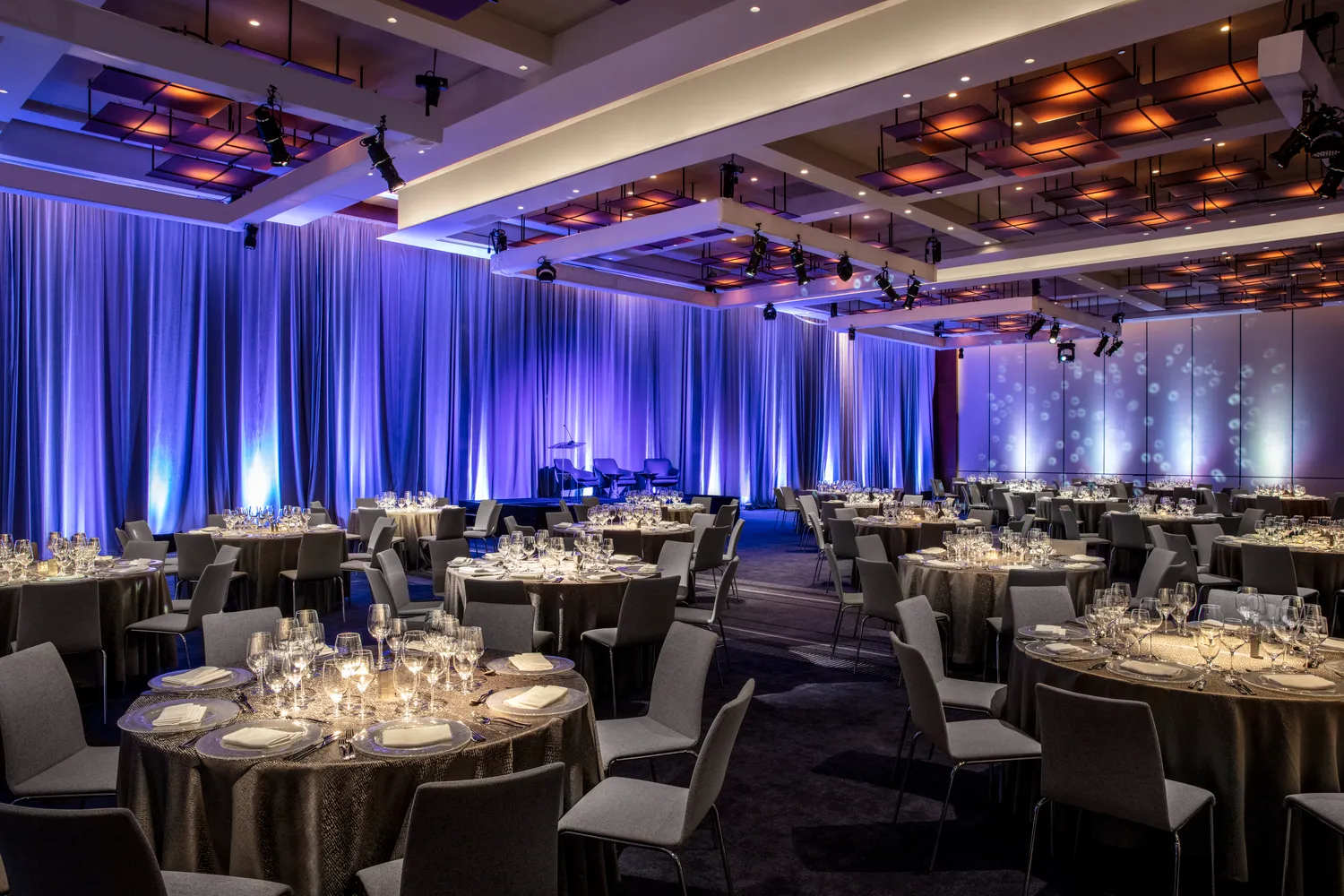 Elegant NYC wedding reception at Conrad New York Downtown. Tables are set for a formal dinner.