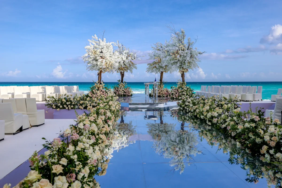 Beach destination wedding ceremony at Kempinski Hotel Cancún with floral aisle and ocean views