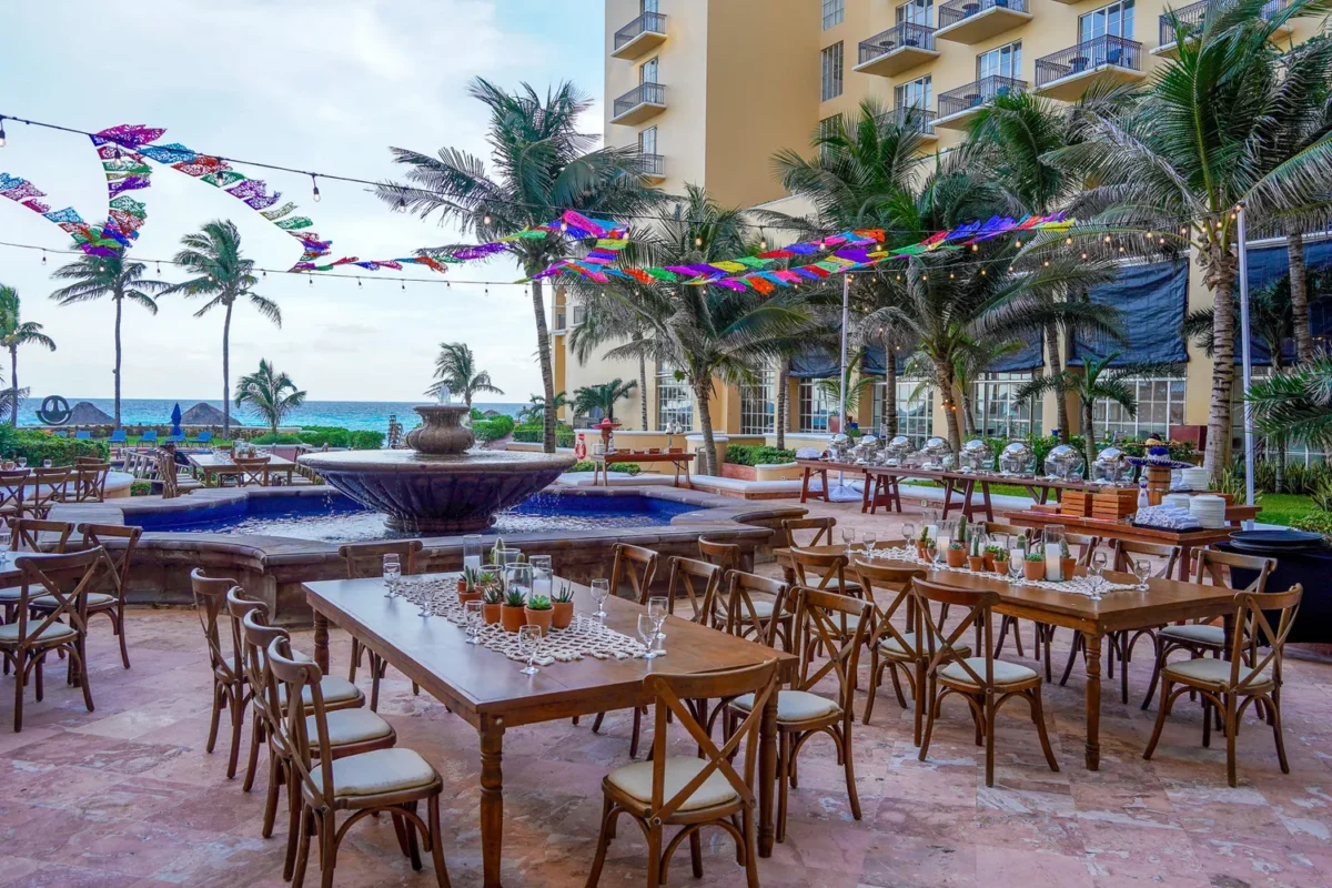 Outdoor destination wedding reception setup at Kempinski Hotel Cancún with tables, chairs, and fountain.