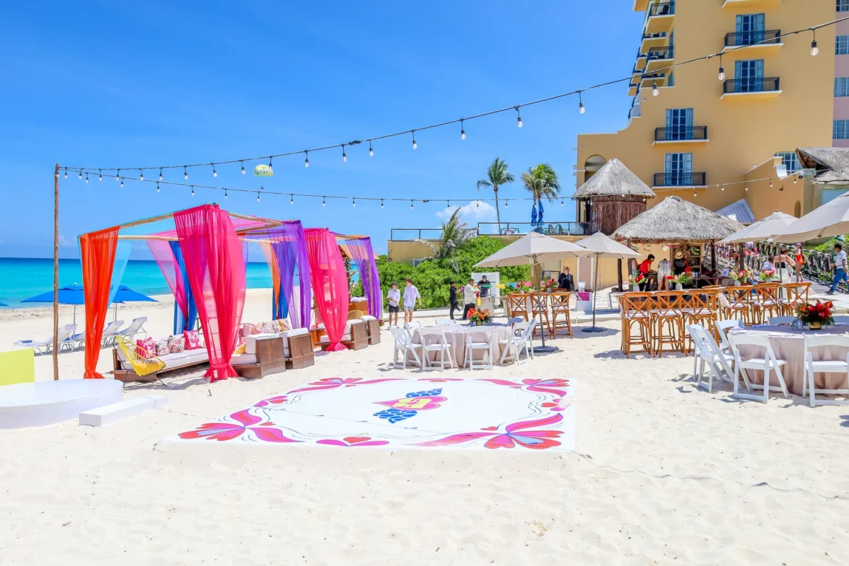 Beachfront destination wedding setup at Kempinski Hotel Cancún, with colorful decorations and dance floor.