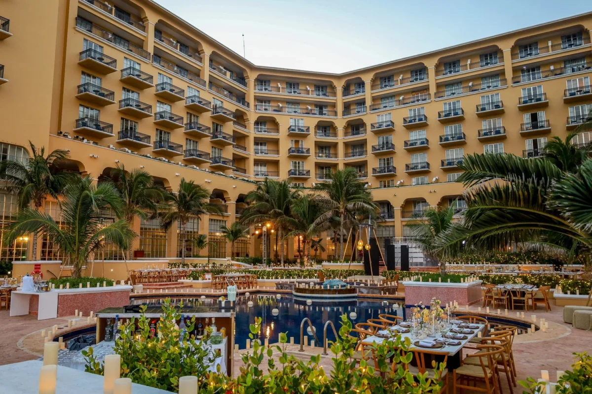 Kempinski Hotel Cancún destination wedding resort pool area set for an event with tables and candles.